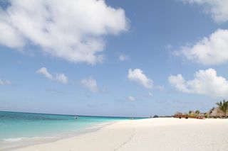 Weißer Sandstrand mit türkisfarbenem Wasser an der Küste Sansibars